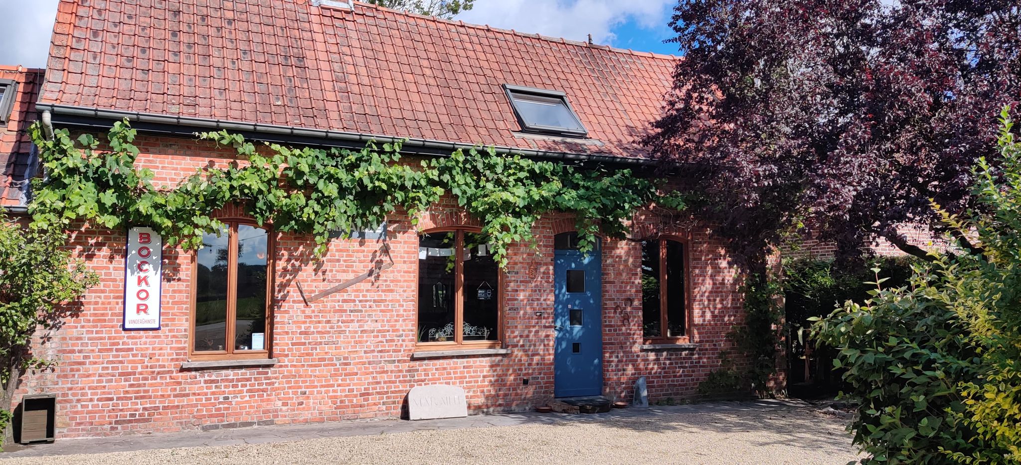 De mooie gevel van het café met groen errond.